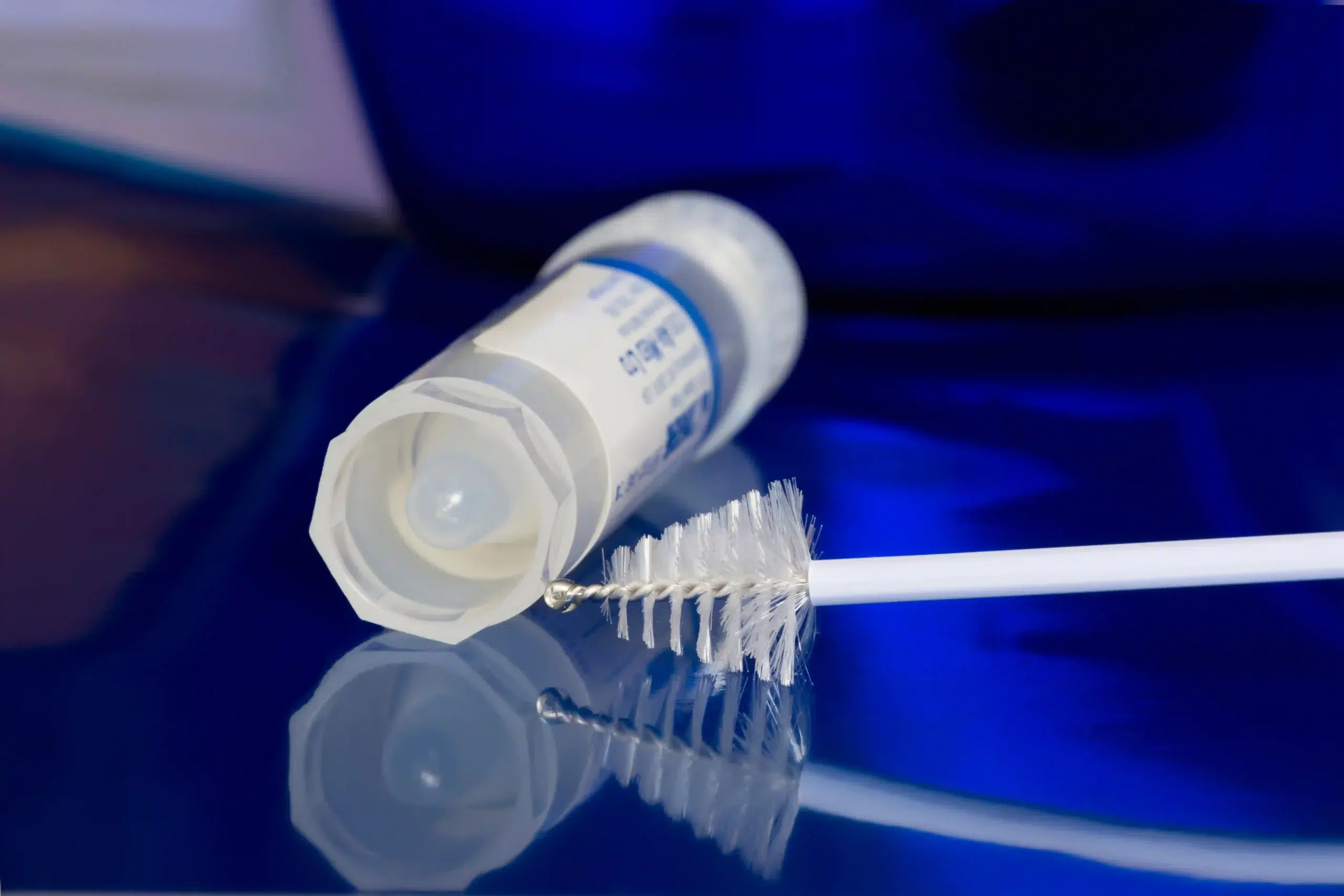 A medical kit with a collection container and a small brush for an HPV test for women.