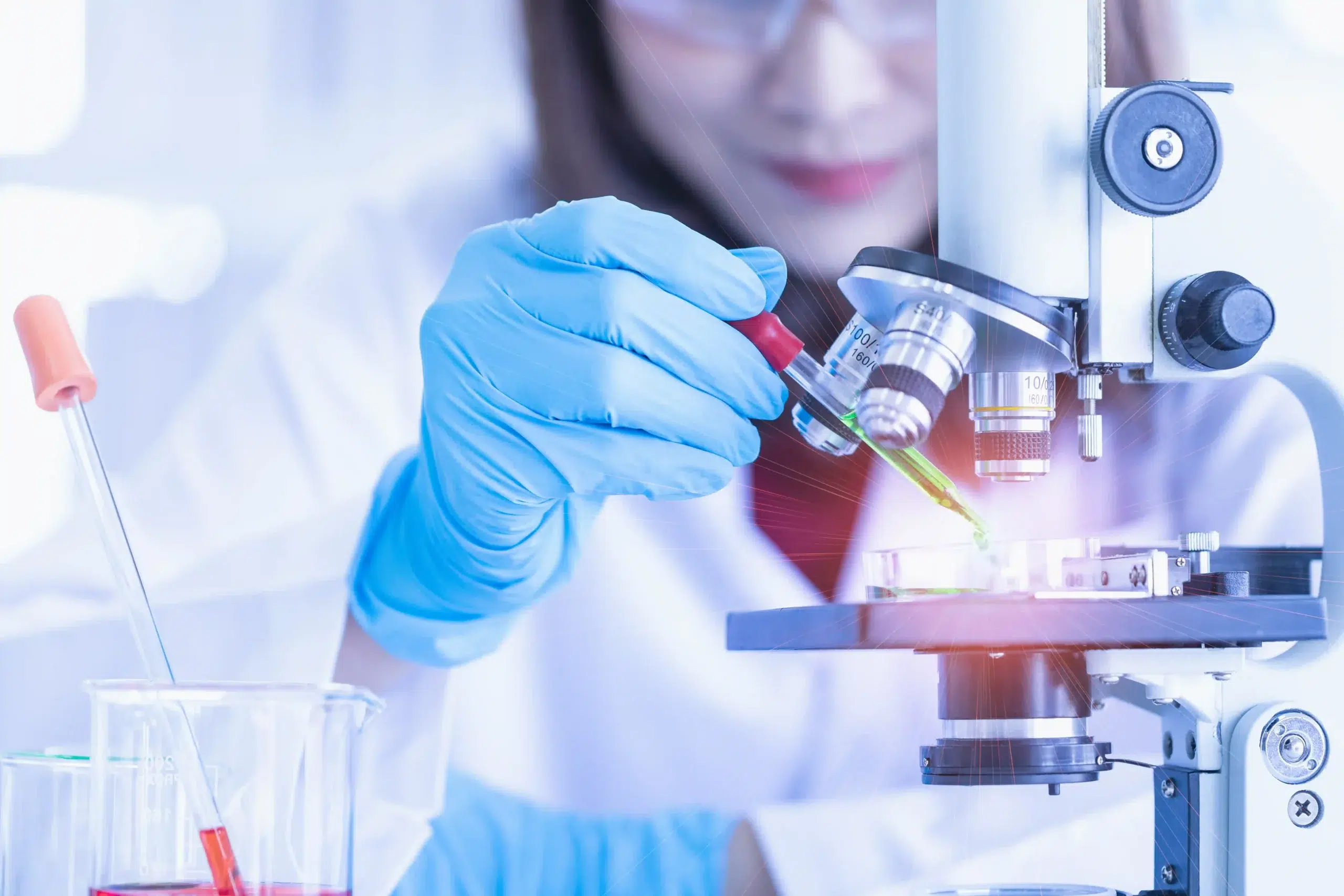 Malaysian scientist performing stem cell research in a lab with a microscope.